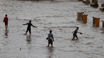 Yemeni children walk through a flooded street following heavy rains in the old quarter of Sana'a, Yemen. Heavy rains and associated floods through Yemen have left at least 16 people dead and damaged dozens of homes and roads. EPA