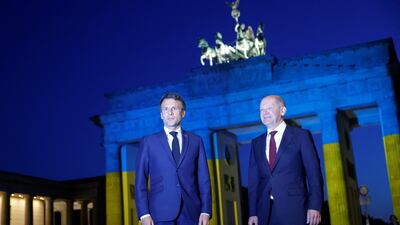 Germany's Chancellor Olaf Scholz and France's President Emmanuel Macron visit the Brandenburg Gate, illuminated in the colours of the Ukrainian flag. Reuters