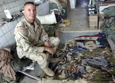 A US army sergeant steps on a carpet showing Saddam Hussein and Saladin at the Office of Reconstruction and Humanitarian Assistance (ORHA) base in Baghdad, 2003. Reuters.