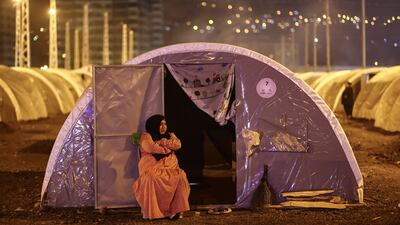 A woman sits in front of her tent inside a camp in the Iskenderun district of Hatay. EPA