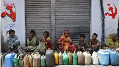 Residents in Kolkata wait outside a ration shop to fill containers with kerosene. The Indian government's five-year economic plan would end subsidies for kerosene and cooking gas.