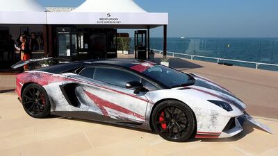 A 2016 Lamborghini Aventador in a head-turning chipped red, white, and black livery.