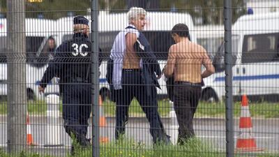 The Air France director of human resources Xavier Broseta, right, and Air France assistant director of long-haul flights Pierre Plissonnier, centre, are protected by a police officer as they flee Air France headquarters at Roissy Airport, north of Paris, France, after scuffles with union activists last year. Jacques Brinon / AP