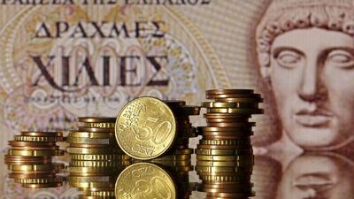 Euro coins are seen in front of a Head of Apollo on an old Greece banknote. Dado Ruvic / Reuters