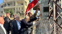 Prime Minister Nawaf Salam plants a Lebanese flag in the ground during a visit to Zawtar Al Gharbiyeh. Reuters