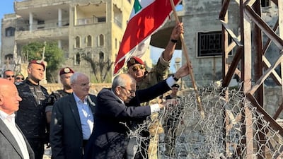 Prime Minister Nawaf Salam plants a Lebanese flag in the ground during a visit to Zawtar Al Gharbiyeh. Reuters
