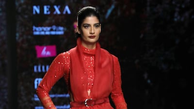 A cinched waist lends a contemporary aura to this Shyamal and Bhumika outfit in bridal red. Rajat Gupta / EPA