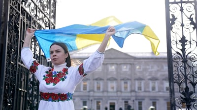 Ukrainian citizen Oleksandra Keshkeval, who is originally from Odesa but has lived in Dublin for a decade, holds the Ukrainian flag outside Leinster House, Dublin, before Mr Zelenskyy's address. PA