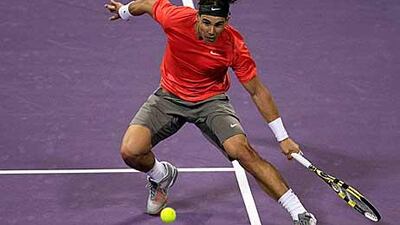 Rafael Nadal of Spain hits a return to Karol Beck of Slovakia during their match in Doha.