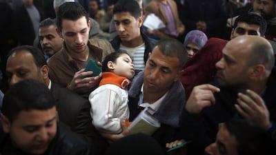 A Palestinian man carries a sleeping girl as he waits with other Palestinians hoping to cross into Egypt to register their names at the Rafah crossing between Egypt and the southern Gaza Strip. Egyptian authorities partially reopened Rafah border crossing, Gaza’s main window to the world, on Saturday for three days after 50 days of its closure.