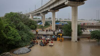 Residents scramble to higher ground after being displaced by flooding in New Delhi. Reuters