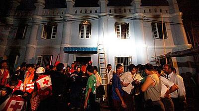 Rescuers tend to injured people outside a mosque in Yangon, Myanmar where 13 people died in a fire what police say was caused by an electrical fault.