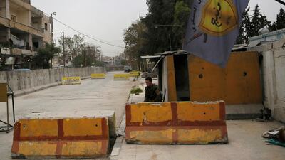 In this March 28, 2018 file photo, a fighter guards the entrance of the Manbij Military Council, the Kurdish-led, US-backed, militia group that defends Manbij, Syria. AP