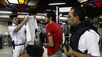 An Egyptian policeman inspects a commuters belongings at Al Shohadaa (Martyrs) metro station, in Cairo, Egypt.