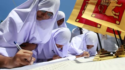 Muslim school girls sign a petition against a UN panel's report about Sri Lanka's war crimes, in Colombo. Reuters