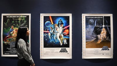 A Sotheby's employee looks at the original Star Wars posters as part of the auction in London. Sotheby's will now host its second sale dedicated to 'Star Wars' collectibles, titled 'Star Wars Online'. AP Photo