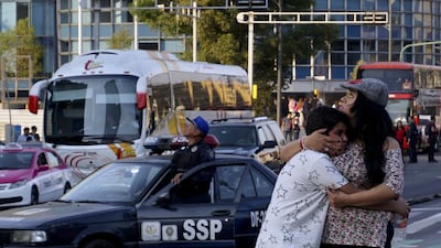 A woman embraces a boy as a powerful earthquake rocks Mexico City on February 16, 2018. Yuri Cortez / AFP