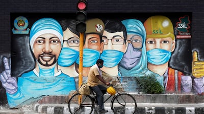 A man rides his bicycle past a graffiti on a road in New Delhi, India. Reuters