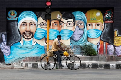 A man rides his bicycle past a graffiti on a road in New Delhi, India. Reuters