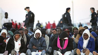 Migrants rest after they disembarked in the Sicilian harbour of Augusta. Italian police arrested 15 African men suspected of throwing about a dozen Christians from a migrant boat in the Mediterranean on Thursday, as the crisis off southern Italy intensified. Antonio Parrinello / Reuters