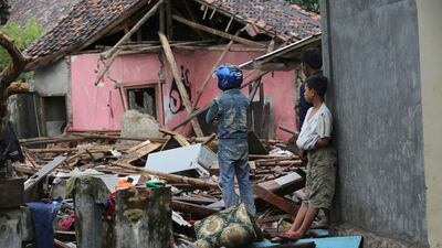 A man inspects his damanged house in Sumur. AP Photo