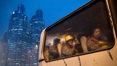 Chinese migrant workers wait in a bus as they leave after their shift at a construction site on December 9, 2014 in Beijing, China. It is estimated that there are more than 40 million construction labourers in China, many of whom come from smaller centers to the country's larger cities to find work. Kevin Frayer / Getty Images