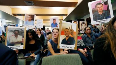 Attendees hold up placards bearing the photographs of people who went missing while trying to cross the border from Mexico into the United States during a hearing held by the Inter-American Commission on Human Rights. AP