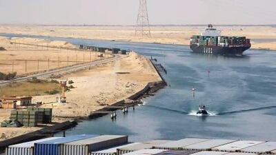 A Suez Canal Authority pilot vessel navigates a convoy of container ships as they pass southbound on the canal. Kristian Helgesen / Bloomberg News
