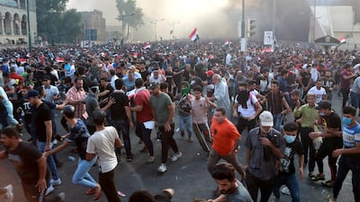 Iraqi protesters run for cover amid tear gas fired by policemen during a demonstration at Tahrir Square, central Baghdad. EPA