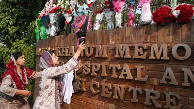 A supporter of Pakistan's former prime minister Imran Khan, places flowers outside the hospital in Lahore where Mr Khan is recovering after an assassination attempt that left him with a gunshot wound to the leg. AFP
