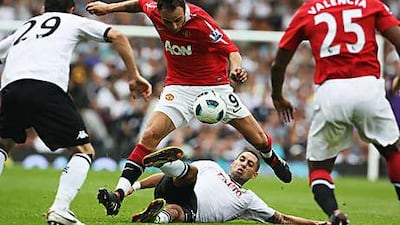 Dimitar Berbatov, centre, the Manchester United striker, is tackled by Fulham's Clint Dempsey as the two sides fought out a 2-2 draw at Craven Cottage.
