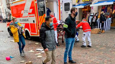 Police look on as rescuers push an injured person into an ambulance at the scene. AFP