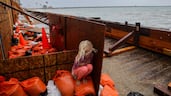 A girl takes shelter from sea spray as Post-Tropical Cyclone Rachel hits the coastline of Long Beach, California. Reuters