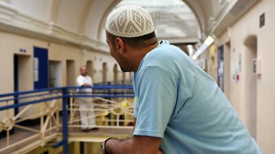 A Muslim inmate on the balcony outside his cell in Wandsworth prison. HMP Wandsworth in South West London was built in 1851 and is one of the largest prisons in Western Europe. It has a capacity of 1456 prisoners. Courtesy: Andrew Aitchison