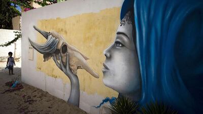 A child stands by a mural by French artist Liliwenn. Joel Saget / AFP Photo