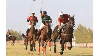 A Ghantoot rider, in red, gallops with a Dubai Polo member, in green, closely in pursuit.