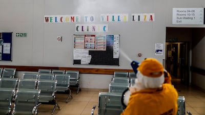 A volunteer sprays disinfectant during a deep cleaning operation inside the Villa Liza Clinic, in Ekurhuleni, South Africa. AFP