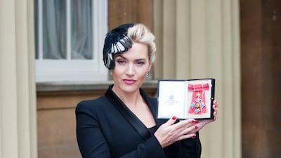 Kate Winslet, in Alexander McQueen, holds her CBE, awarded to her by Queen Elizabeth II, during an Investiture ceremony at Buckingham Palace on November 21, 2012, in London, England. Getty Images