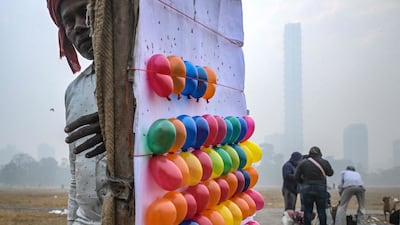 A balloon-shooting board is set up for customers at an urban park on a foggy morning in Kolkata, India. AFP