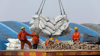 Workers load imported soybeans at a port in Nantong in east China's Jiangsu province. China said it would levy tariffs on imports of 106 US products including soybeans, automobiles, chemicals and aircraft. Chinatopix via AP