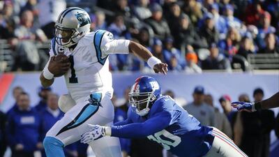 Carolina Panthers quarterback Cam Newton outruns New York Giants defensive lineman Jason Pierre-Paul during their NFL contest on Sunday. Kathy Willens / AP / December 20, 2015
