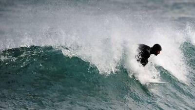 Surfing teacher Mike Dobos glides on a wave in the northern Spanish Basque village of Mundaka.