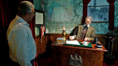 A Palestinian looks at a scene depicting the British foreign secretary Arthur Balfour signing the document that led to the creation of Israel, at street artist Banksy's Walled Off hotel in the Israeli-occupied West Bank town of Bethlehem on October 31, 2017. Musa Al Shaer / AFP