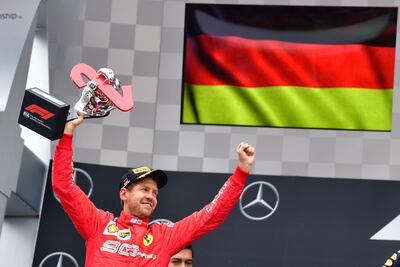 Ferrari's Sebastian Vettel celebrates with the trophy on the podium after the German Grand Prix at Hockenheim. Andrej Isakovic / AFP