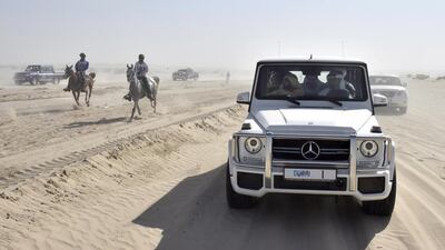 Sheikh Mohammed drives alongside the riders during the endurance race. WAM