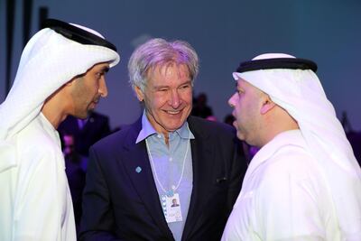 Harrison Ford speaks to the Emirati environment minister Dr Thani Al Zeyoudi, left, and another official at the summit on Monday. Chris Whiteoak / The National