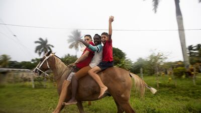 People on a horse wave in the streets of Coloma, a town through which Hurricane Ian is expected to enter, in Pinar del Rio province, Cuba. EPA