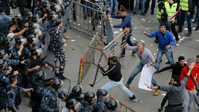Lebanese anti-government protesters clash with riot policemen as they try to reach the government building in central Beirut. AP