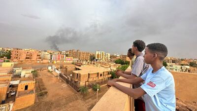 People watch as smoke rises during clashes between the army and the paramilitary Rapid Support Forces in Omdurman. Reuters
