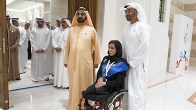 Sheikh Mohamed bin Zayed and Sheikh Mohamed bin Rashid stand for a photograph with a participant.